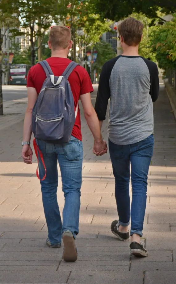 image of two men holding hands while walking